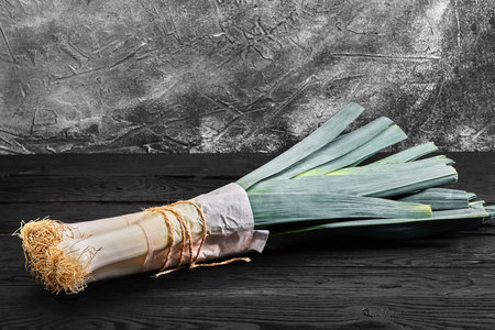 Farm fresh organic leek, spring salad ingredient on wooden tableの写真素材