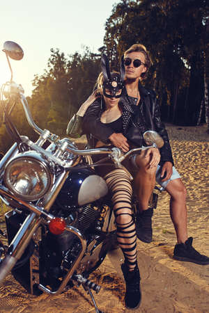 Sexy couple of bikers on the vintage custom motorcycle, girl in a rabbit maskの写真素材