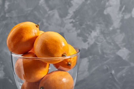 Fresh orange Tashkent lemons or Meyer lemons on concrete background. Vitamin Cの写真素材