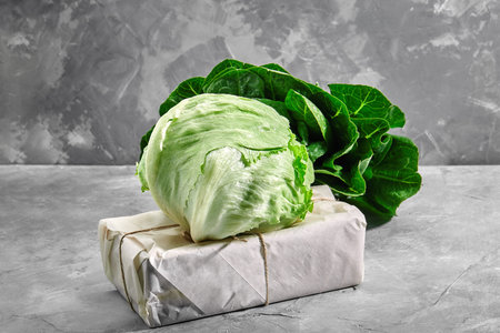 Head of fresh organic iceberg lettuce over vintage concrete background. Selective focus.