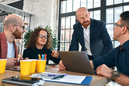 Beautiful business people are using gadgets, talking and smiling during the conference in office. Selective focusの写真素材