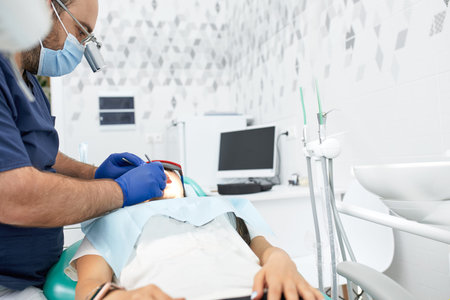 people, medicine, stomatology and health care concept - happy male dentist with woman patient at...