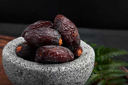 Bowl of dried dates on dark wooden backgroundの写真素材