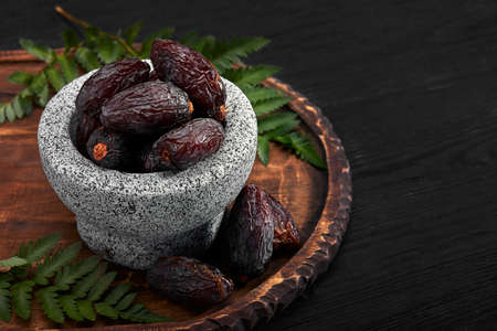 Bowl of dried dates on dark wooden backgroundの写真素材