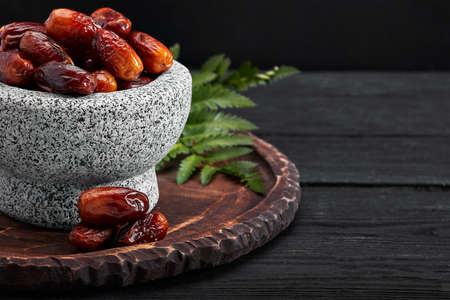 Bowl of dried dates on dark wooden backgroundの写真素材