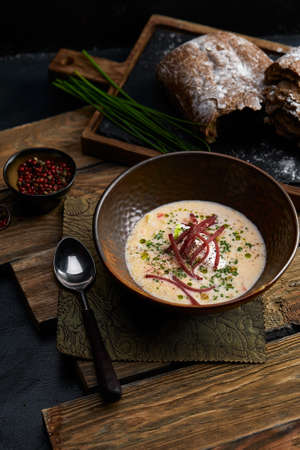Traditional Italian soup with barley and bresaola on old wooden background. Selective focus. Dark tone.の写真素材