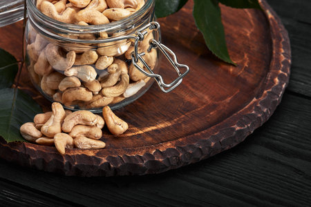 Bowl with cashew nuts on wooden table. Delicacies