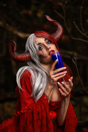 Stylish and fashionable model girl in the image of Maleficent posing among mystic forest - fairytale story, cosplay. Halloweenの写真素材