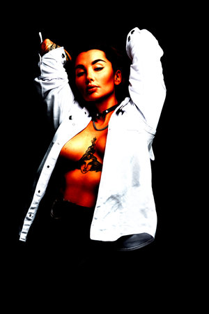 Portrait of sexy young woman undressing on grey background. Female model taking her shirt off.の写真素材