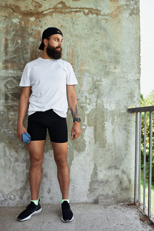 Concentrated male athlete running up stairs to make training more intensive. Sporty handsome young...