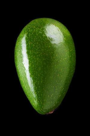 green fresh avocado over black background close-up