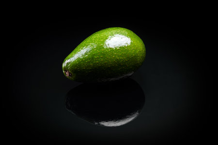 green fresh avocado over black background close-upの写真素材