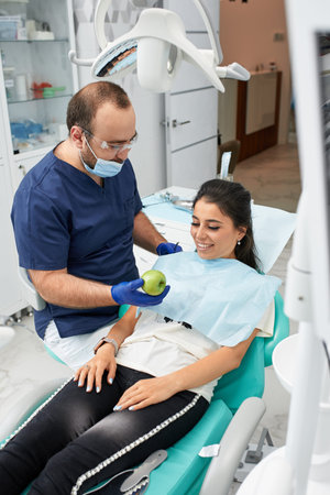 people, medicine, stomatology and health care concept - happy male dentist showing work plan to...
