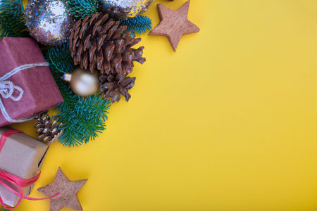 Spruce branch, cones and vintage toys decoration on christmas or new year on yellow background.の写真素材