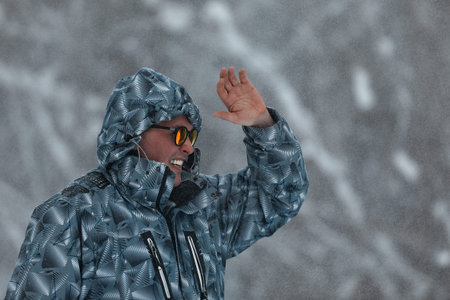 Portrait of serious man in sunglasses and warm clothes walking in snowy forest