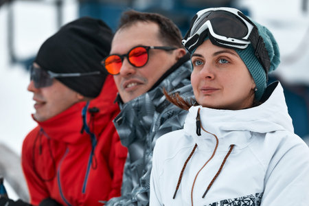 group of skiers friends on the mountain are resting and drinking coffee from a  on the background of...