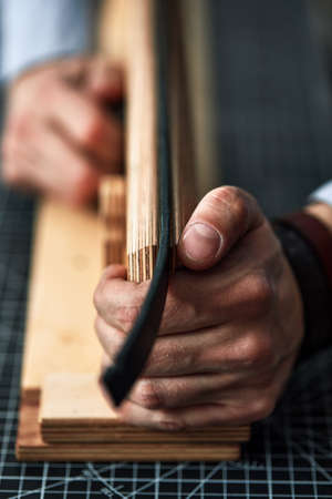 leather craftsmen working making measupenets in patterns at table in workshop studioの写真素材