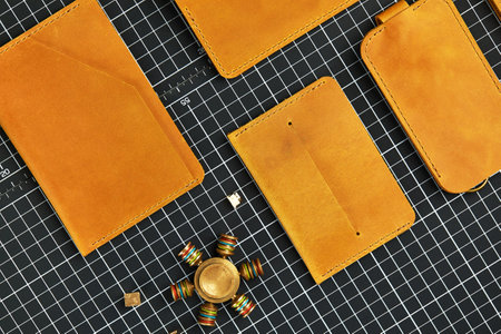 Set of handmade leather goods, key holder rings, wallet, purse, notepad, handbook. Handcrafted leather goods, close-up.の写真素材
