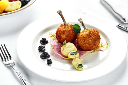 Two Chicken Kievs on a light plate, with potatoes and lettuce, authors serving of Kiev cutletsの写真素材