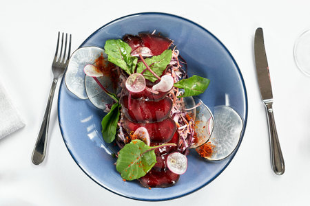 Bresaola on a blue plate with lettuce leaves, top view, serving beef jerky from the chef.の写真素材