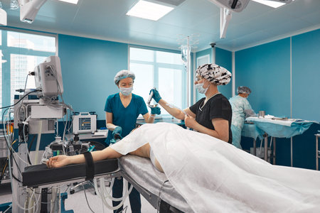 Teams of a doctor in a modern operating room, connects the patient to an artificial lung ventilation device, anesthesiologists prepare the patient for lung surgeryの写真素材