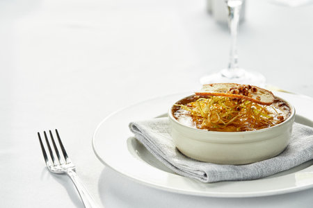 Mushroom julienne with croutons on a table with white tablecloths, light dishes with mushroom julienne on a light background, copy space, festive tableの写真素材