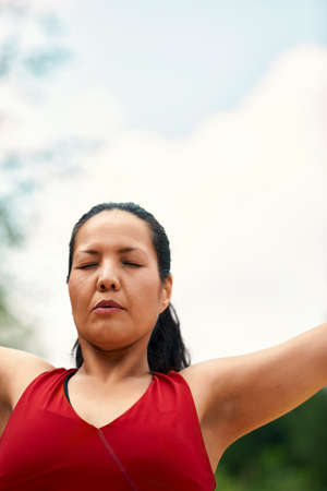 Adult asian woman doing yoga in nature, doing stretching and flexibility exercises, yoga class for adult womenの写真素材