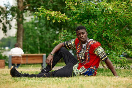 An African man in South African national clothes, a black young man resting in a park in national clothes.の写真素材