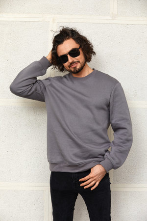 Modern young man in sunglasses with long hair, handsome man in glasses on the background of the...