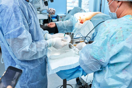 Surgeons during surgery with breast implants in their hands, installation of breast implants, surgery. Plastic surgery, breast correction, mammoplasty.の写真素材