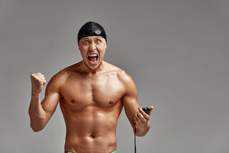 A coach with a stopwatch in his hands, a sports swimming coach with a timer in his hands, gray...