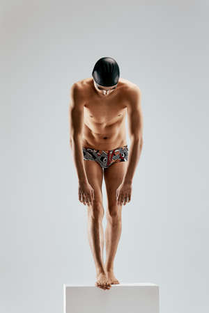 Portrait of a swimmer who is preparing for a jump. The concept of swimming and water games. Front view. Mixed mediaの写真素材