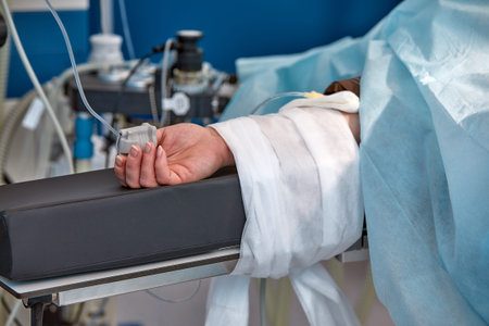 The patients hand is under the IV with a pulse oximeter on the finger. Medical services.の写真素材