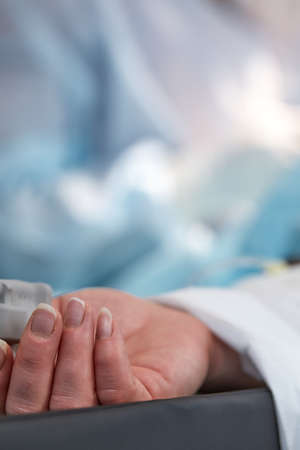 The patients hand is under the IV with a pulse oximeter on the finger. Medical services.の写真素材
