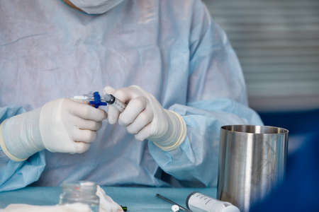 Perspective of a patient on a operating table who sees the doctor above with a syringe in her hand. Selective Focusの写真素材