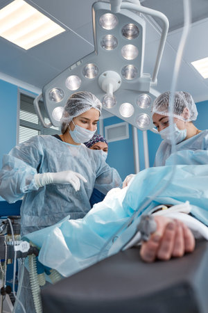 Concentrated Surgical team operating a patient in an operation theater. Well-trained...
