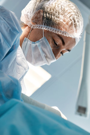 Close-up of a female surgeon in an operating room, a doctor with a tense expression on his face, in...