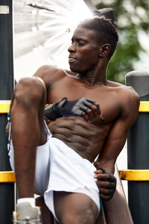 Working out in the morning. Young strong african man in sportswear exercising outdoors. Sport,...