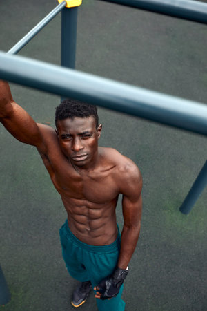 Muscular african man doing push ups in the park. Strong male athlete working out outdoors.の写真素材