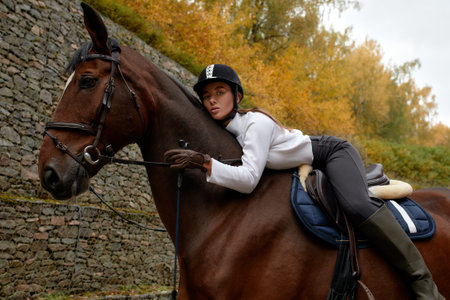 Beautiful brunette on a horse on the background of an autumn landscape. Horseback riding, active...