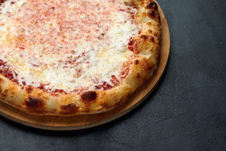 Pizza Margherita on dark stone background, top view. Flyer and poster for Restaurants or pizzerias, template with delicious taste margarita pizza, mozzarella cheeseの写真素材