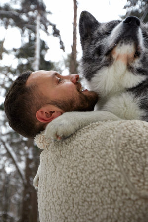 Men playing with siberian husky in winter forest and park, animals and ecology. Pet lover. Dog -...