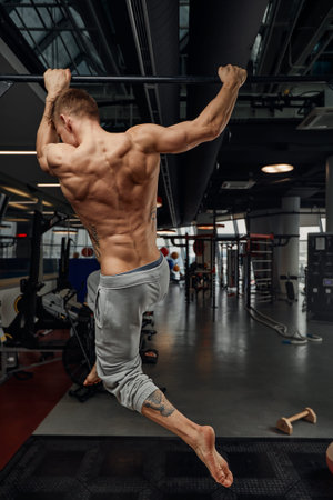 fitness, sport, bodybuilding and people concept - young man doing push-ups on gymnastic rings in...