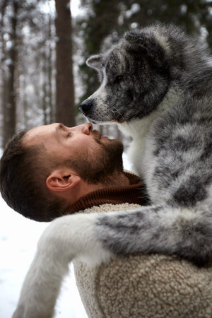 Men playing with siberian husky in winter forest and park, animals and ecology. Pet lover. Dog -...