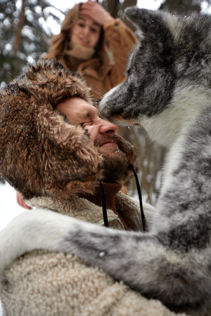 Portrait of a young beautiful couple of European appearance with a husky dog in the winter forest