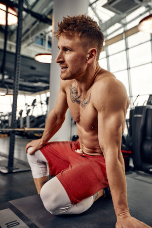 Portrait handsome and confident young Caucasian man at gym background. Face of brutal muscular sexy...