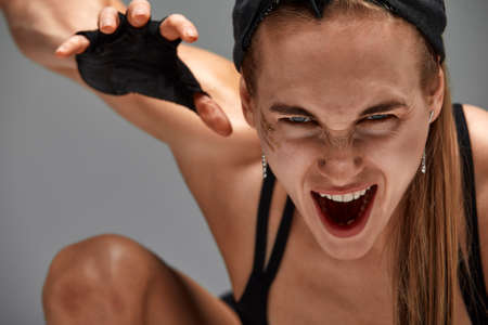 Portrait of female anger, animal instinct, demonstrating their incredible flexibility with the movement of animal flow in the studio on a gray background.の写真素材