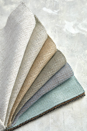 catalog of interior luxury fabric sample chart showing texture of fabric in pastel beige color tone....