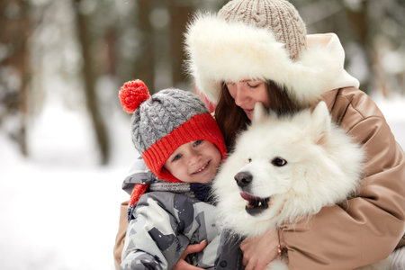 Happy family moments, winter games concept. Side view of happy mother carrying and hugging cute...