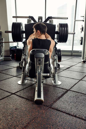 Training legs in the simulator, the athlete works with his legs on the simulator, working out the muscles on the legsの写真素材